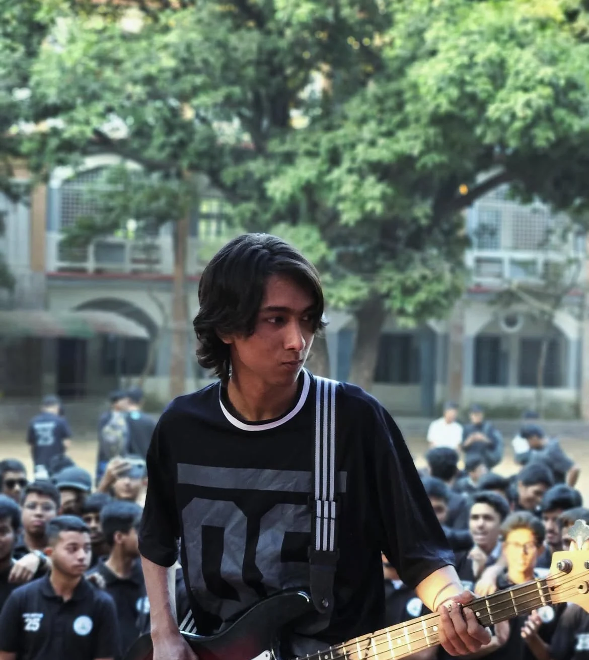 Playing a guitar in front of a crowd at an outdoor event